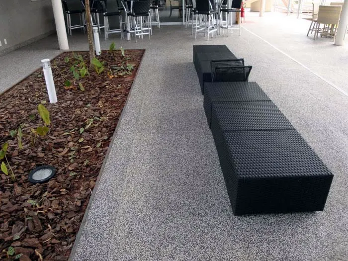 Piso granitina cinza em área de convivência com bancos e jardim